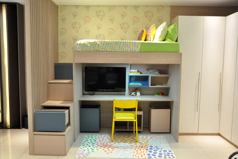 Quarto infantil planejado com cama alta e bancada de estudo